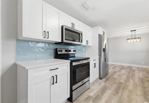 a kitchen with stainless steel appliances granite countertop a stove a microwave and a refrigerator
