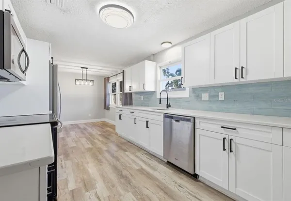 a kitchen with a refrigerator sink and cabinets