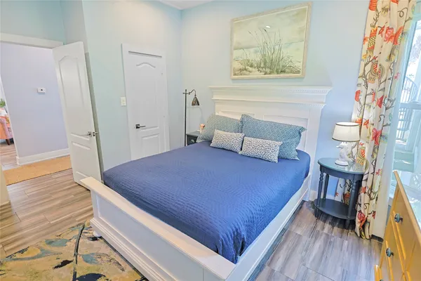 a bedroom with a bed and wooden floor