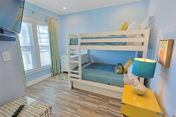 a bedroom with a bed and large windows