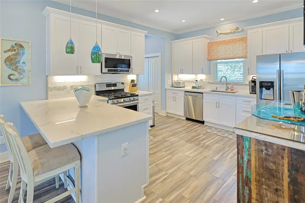 a kitchen with a sink a counter top space stainless steel appliances and cabinets