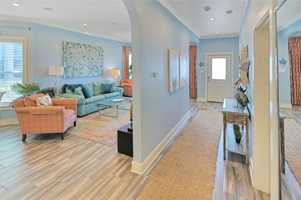 a living room with furniture and a wooden floor