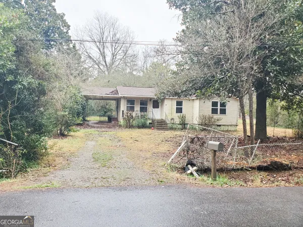 a front view of a house with a yard tree and outdoor seating