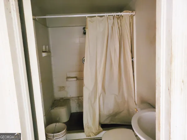 a white toilet sitting next to a shower curtain
