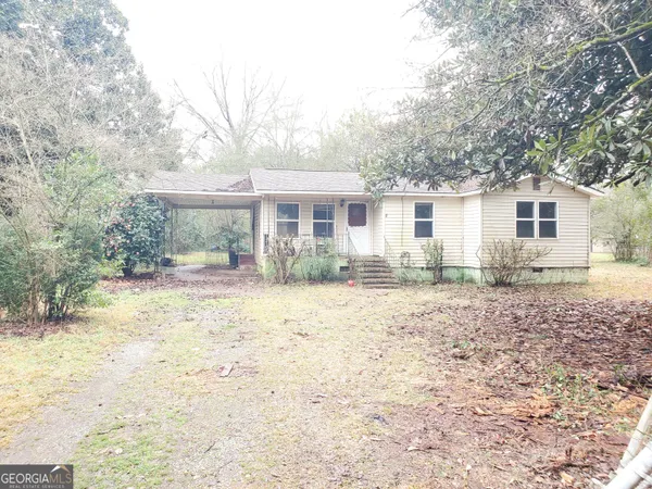 a front view of a house with a yard and trees