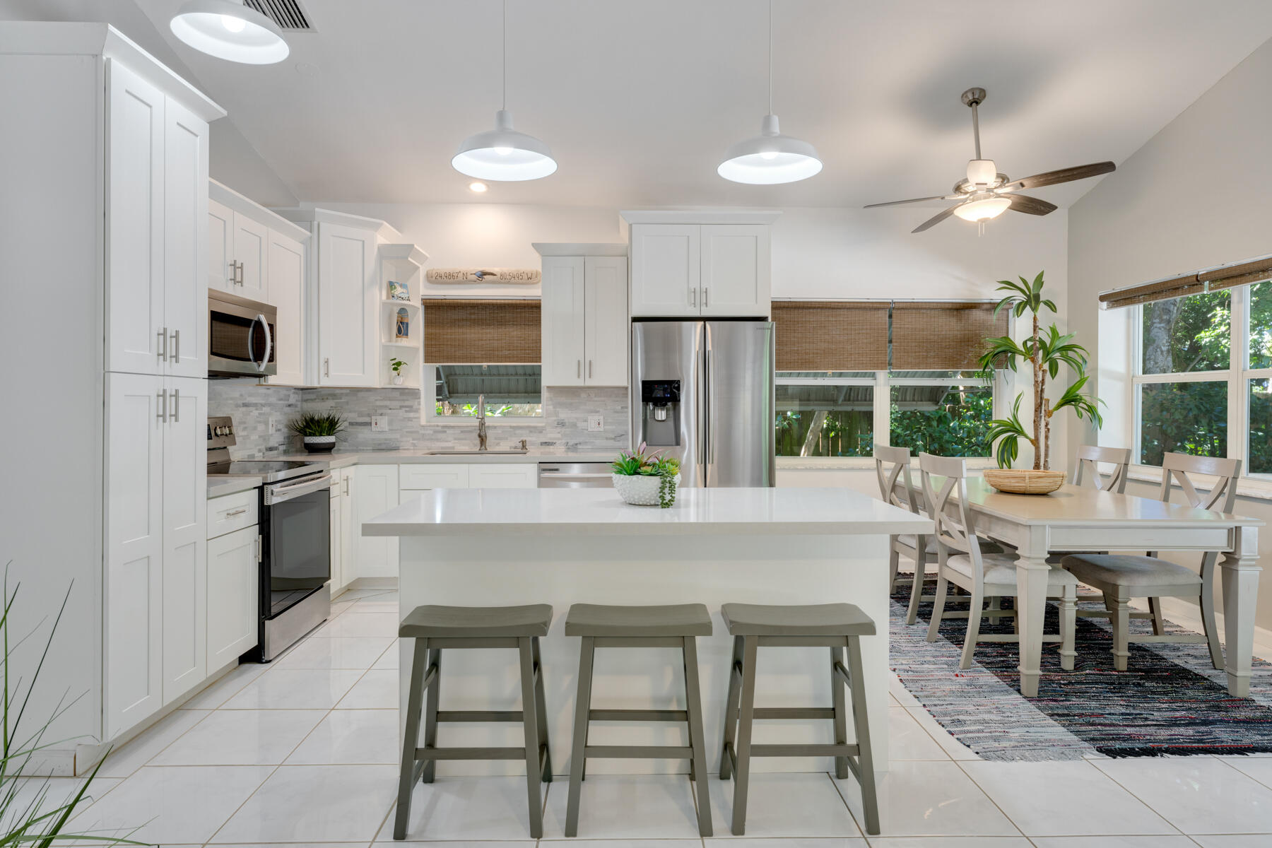 150 Apache Street Tavernier, FL 33070 - Photo 12 of 32 a kitchen with a table chairs refrigerator and cabinets