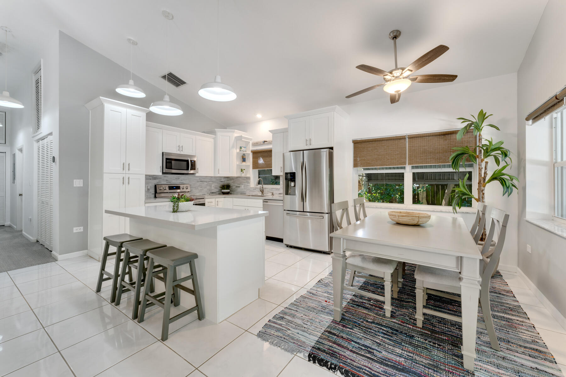 150 Apache Street Tavernier, FL 33070 - Photo 9 of 32 a kitchen with stainless steel appliances kitchen island granite countertop a refrigerator a stove a sink dishwasher with a dining table and chairs