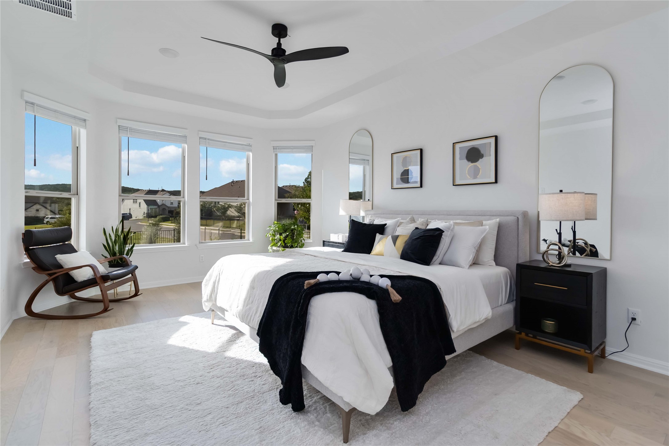 4705 Modena Bay Bend Leander, TX 78641 - Photo 16 of 40 Primary bedroom with bay windows, ceiling fan and tray ceiling