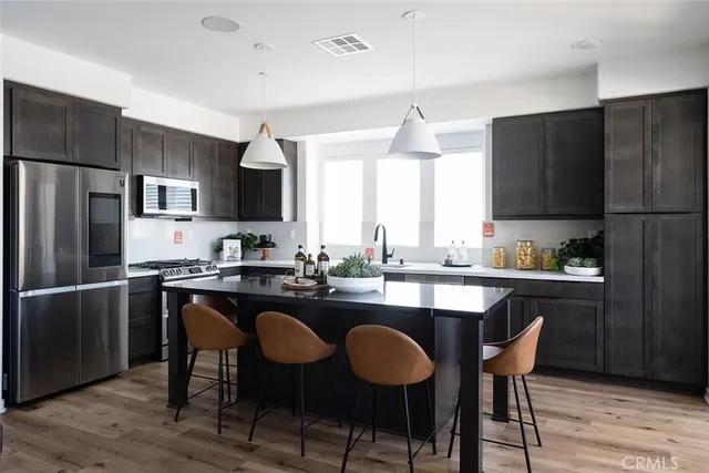a kitchen with a table chairs refrigerator and cabinets