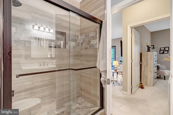 a bedroom with bed and large windows with chair