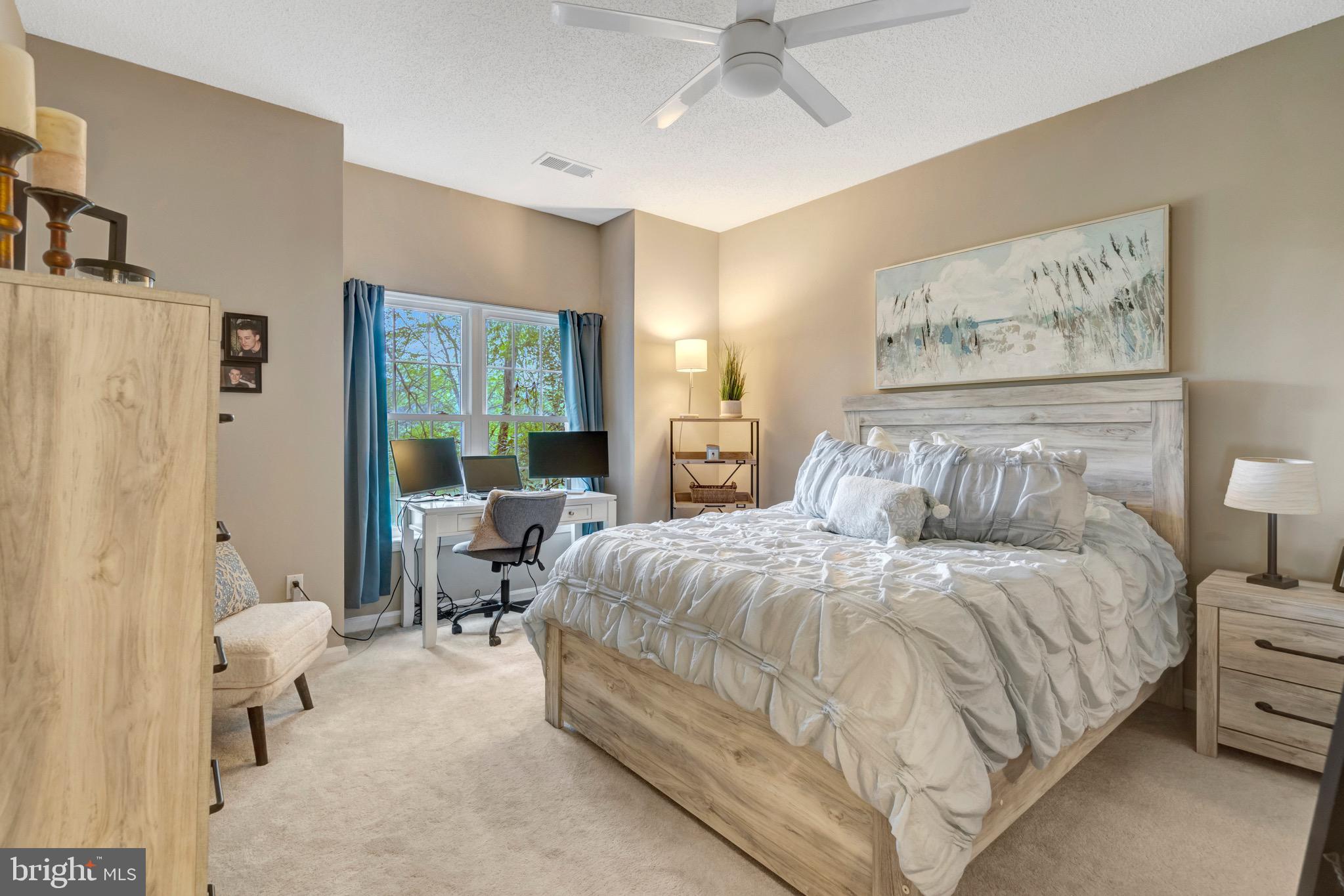 1712 Lake Shore Crest Drive, Unit 14 Reston, VA 20190 - Photo 14 of 24 a bedroom with bed and large windows with chair