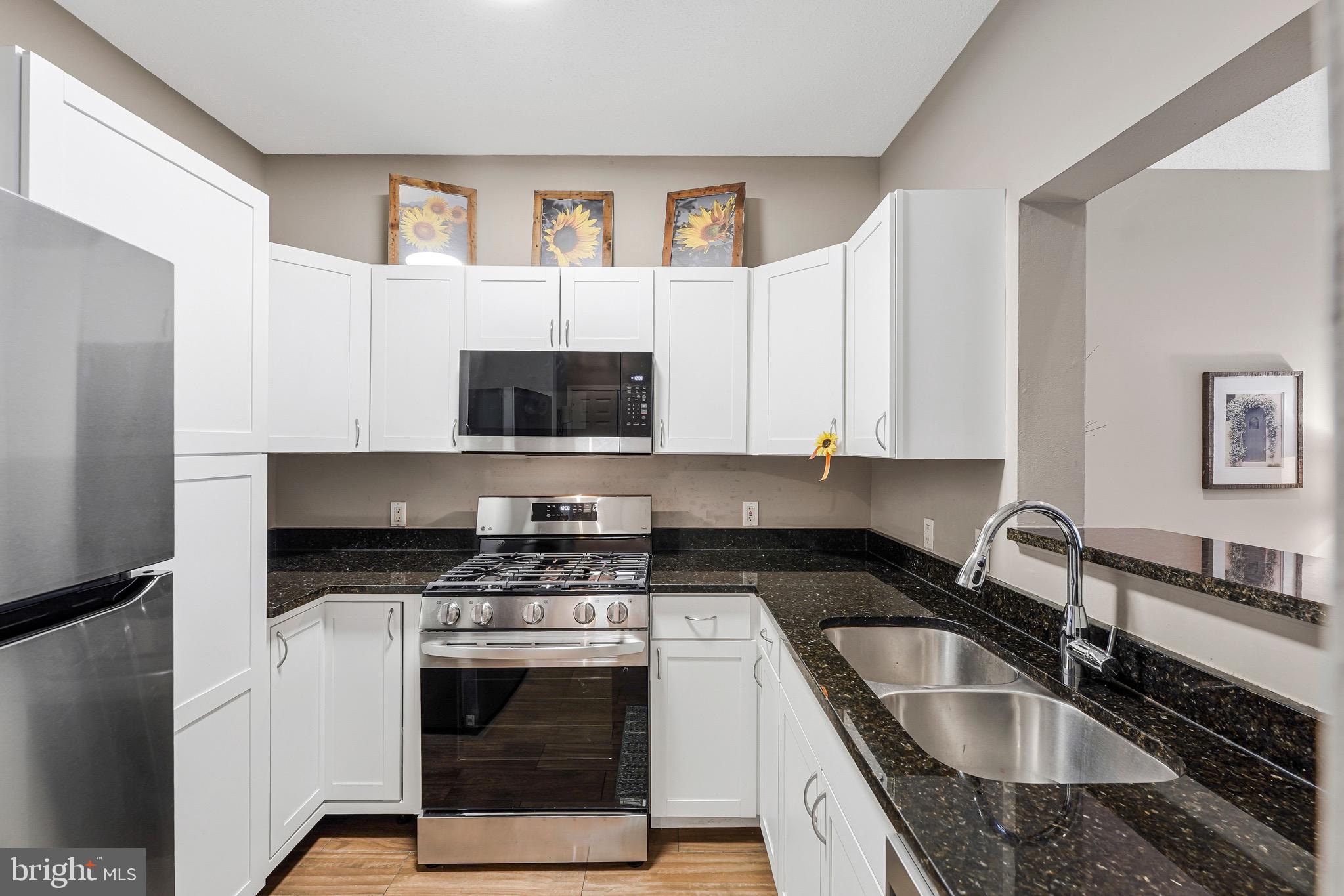 1712 Lake Shore Crest Drive, Unit 14 Reston, VA 20190 - Photo 6 of 24 a kitchen with stainless steel appliances granite countertop a sink stove and microwave