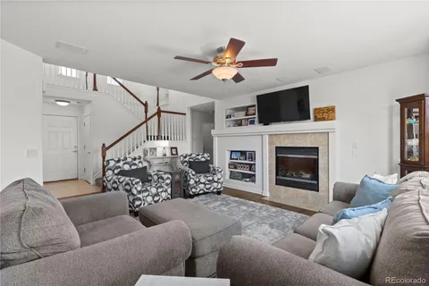 a living room with furniture a flat screen tv and a fireplace