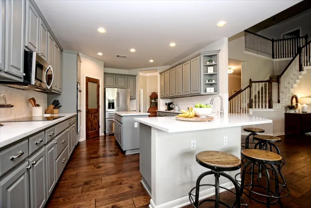 a kitchen with stainless steel appliances kitchen island granite countertop a sink and cabinets