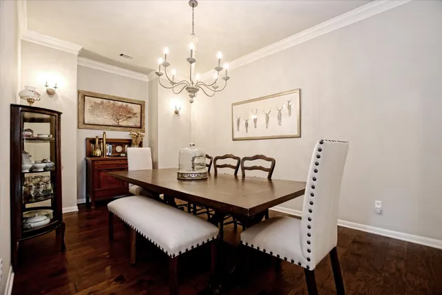 a dining room with furniture a chandelier and wooden floor