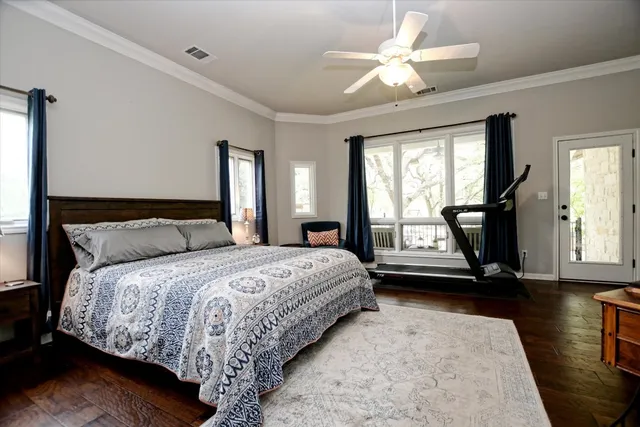 a bedroom with a bed a chandelier and a large window