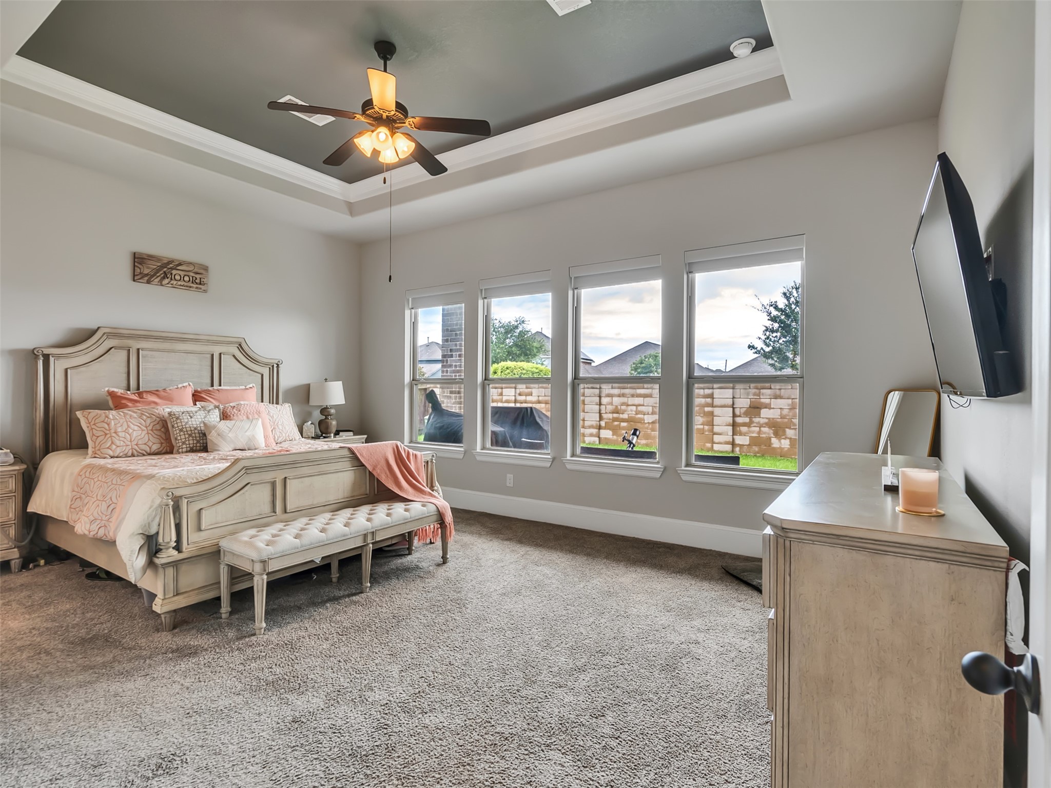 10302 Muir Peak Drive Rosharon, TX 77583 - Photo 18 of 40 Welcome to the Primary bedroom suite where natural lighting and tray ceilings offer a comfortable and stylish ambiance.