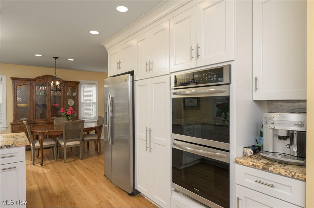 4037 Riveredge Road Cleveland, OH 44111 - Photo 15 of 30 Kitchen featuring white cabinetry, light stone counters, and appliances with stainless steel finishes
