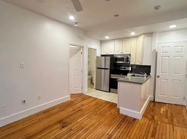 a kitchen with granite countertop a refrigerator and a stove top oven