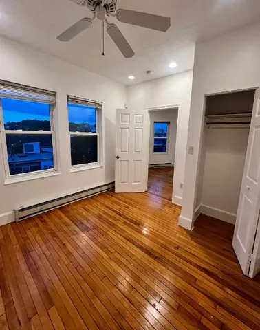 a view of empty room with wooden floor and window