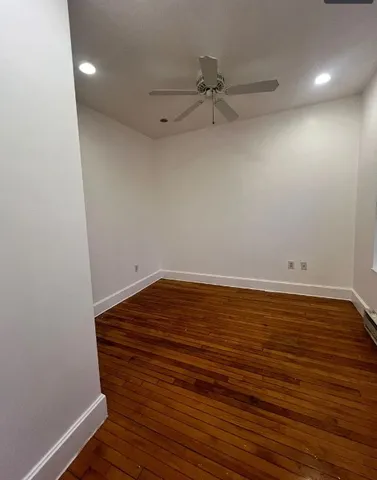 a view of room with wooden floor and fan
