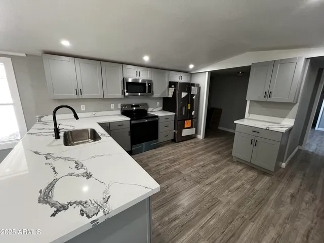 a kitchen with stainless steel appliances granite countertop a refrigerator sink and stove