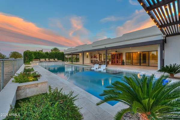 a kitchen with stainless steel appliances granite countertop a refrigerator a sink and white cabinets with wooden floor