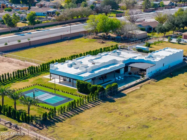 an aerial view of a house with swimming pool and outdoor seating