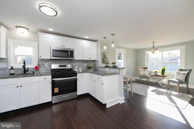 a kitchen with sink a microwave and cabinets