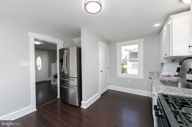 a kitchen with a refrigerator and a stove top oven