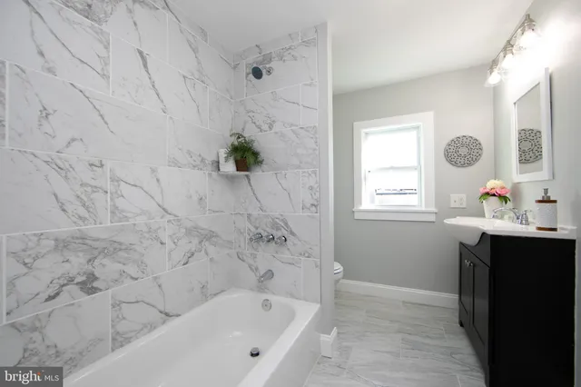 a bathroom with a bathtub sink and window