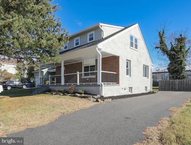 a front view of a house with a yard covered with snow