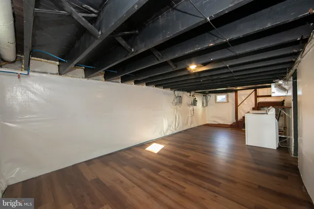 a view of water heater room with wooden floor