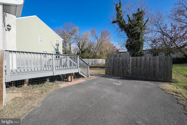 a white house that has a small yard and wooden fence