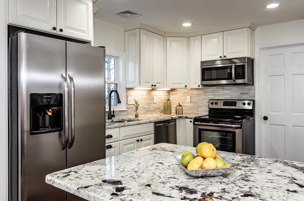 a kitchen with stainless steel appliances granite countertop a stove refrigerator and microwave