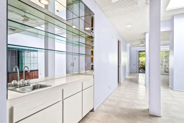 a hallway with white cabinets and chandelier