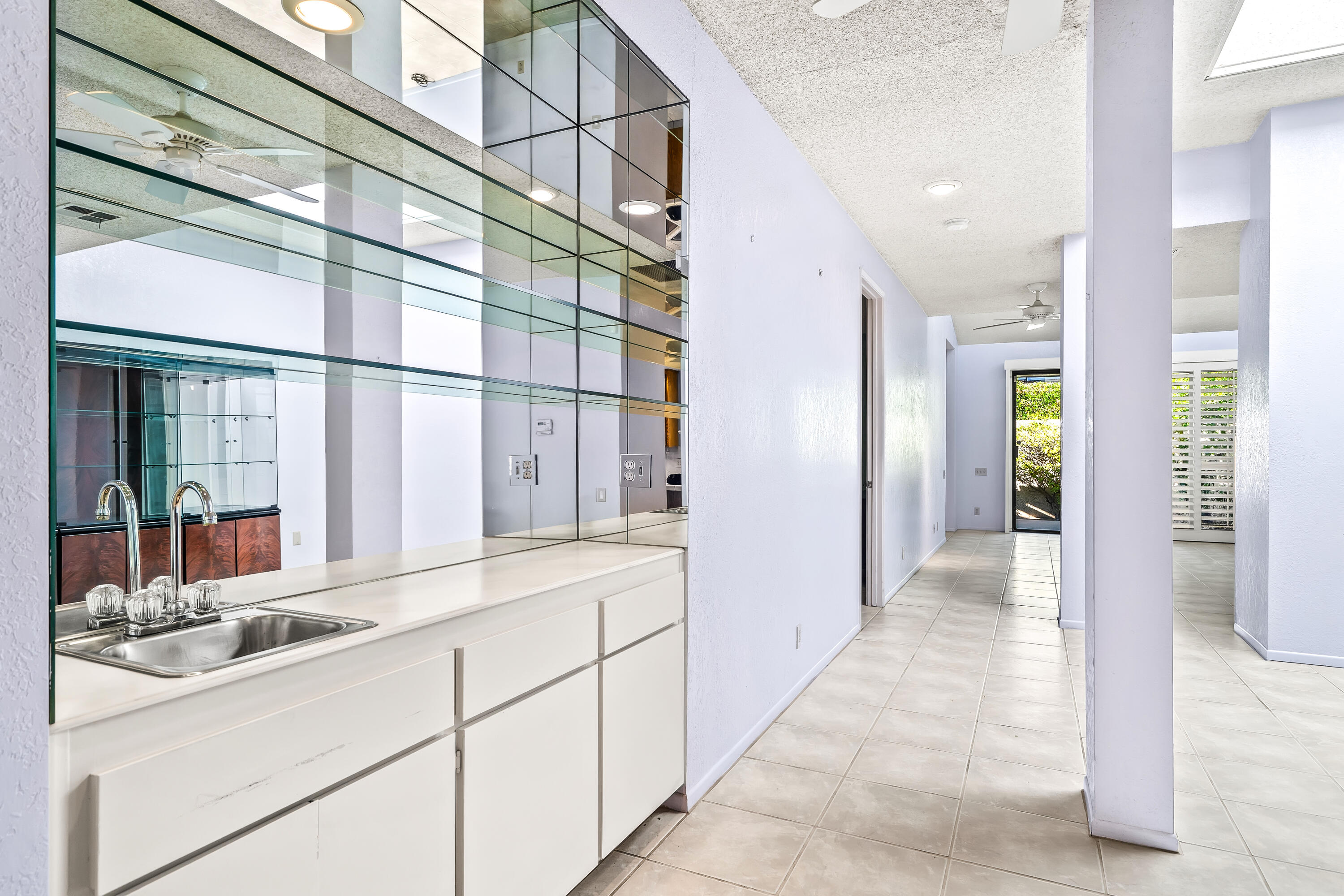 1384 East Andreas Road Palm Springs, CA 92262 - Photo 18 of 46 a hallway with white cabinets and chandelier