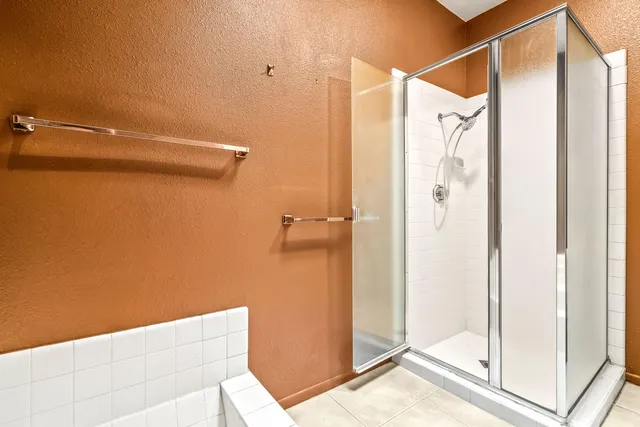a bathroom with a shower and a glass door