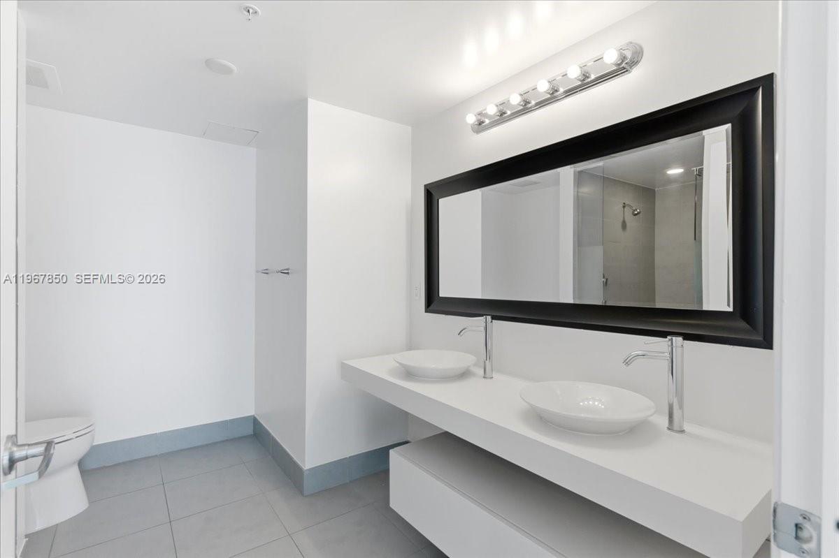 92 Southwest 3rd Street, Unit 3804 Miami, FL 33130 - Photo 19 of 36 a bathroom with a sink and a mirror