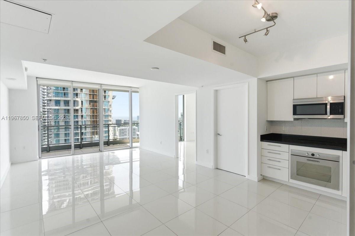 92 Southwest 3rd Street, Unit 3804 Miami, FL 33130 - Photo 4 of 36 a large kitchen with cabinets and glass windows