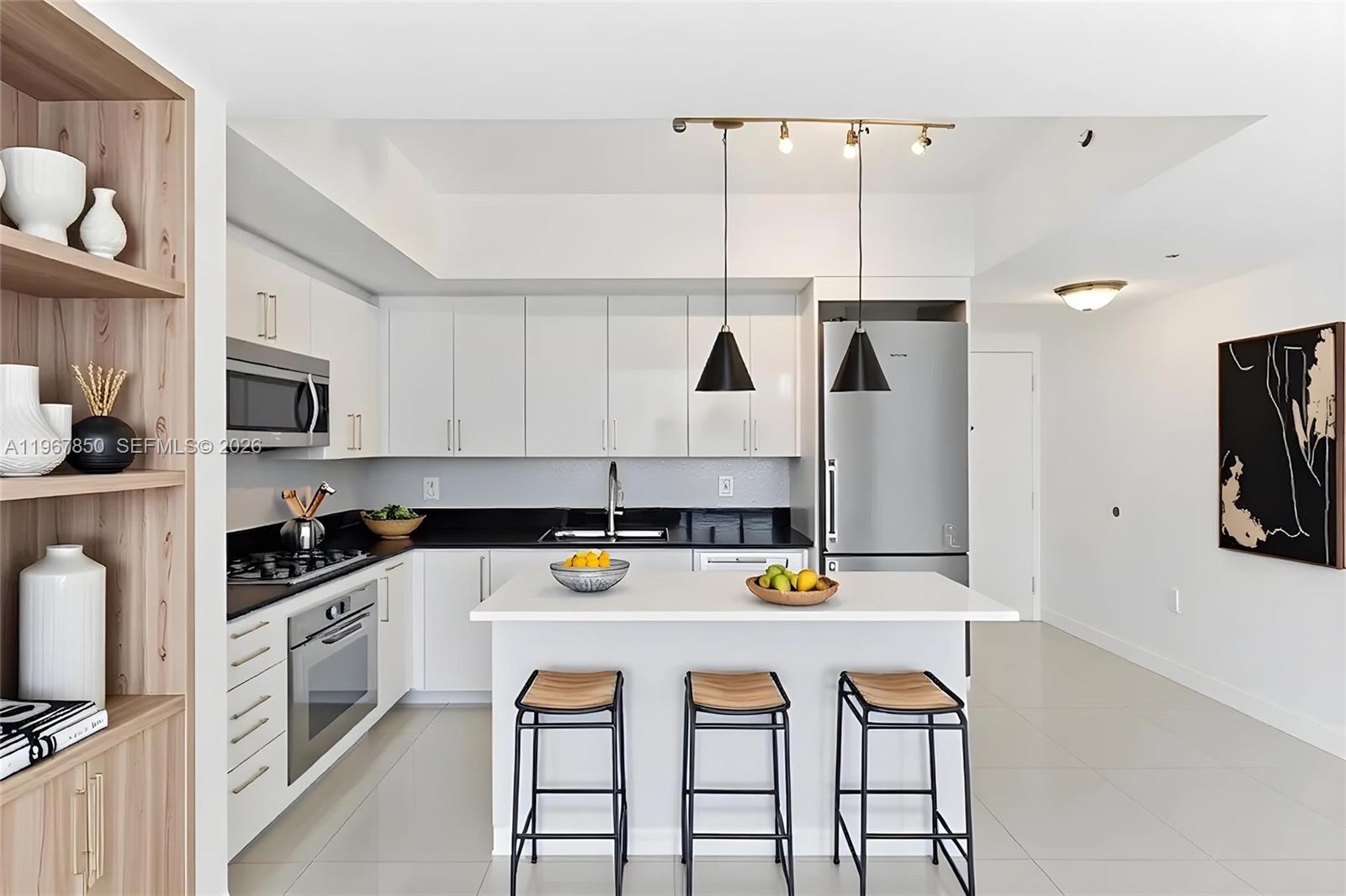 92 Southwest 3rd Street, Unit 3804 Miami, FL 33130 - Photo 6 of 36 a kitchen with a sink a stove and chairs with white stainless steel appliances