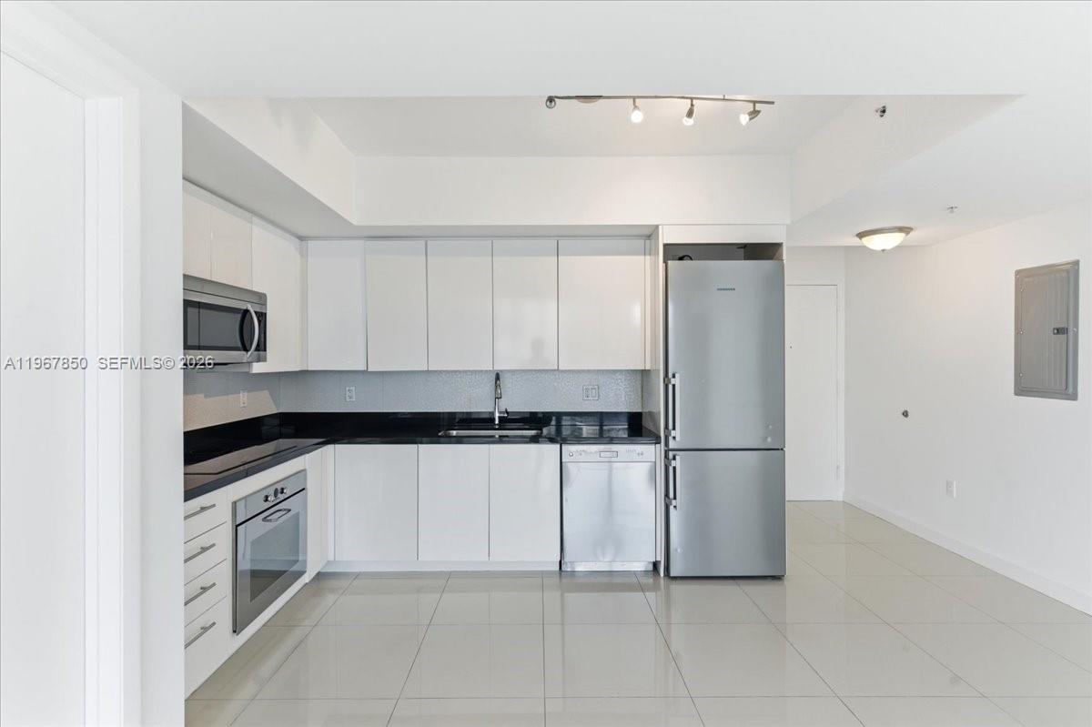 92 Southwest 3rd Street, Unit 3804 Miami, FL 33130 - Photo 7 of 36 a kitchen with granite countertop cabinets and steel stainless steel appliances