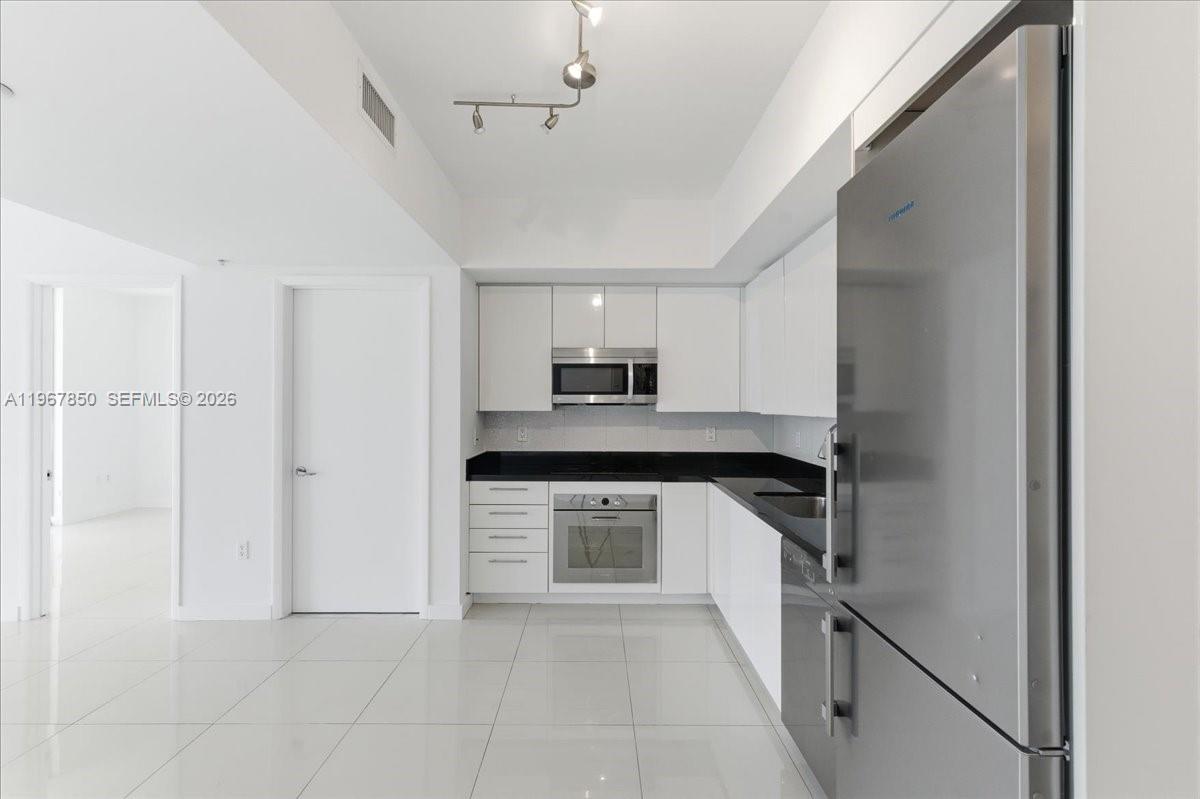 92 Southwest 3rd Street, Unit 3804 Miami, FL 33130 - Photo 9 of 36 a kitchen with granite countertop a refrigerator and a sink
