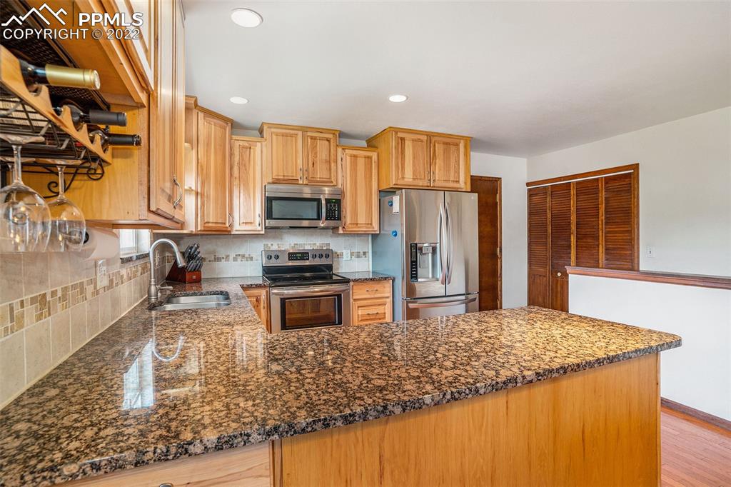 4810 Airport Road Colorado Springs, CO 80916 - Photo 11 of 41 a kitchen with stainless steel appliances granite countertop a refrigerator a stove top oven a sink and dishwasher