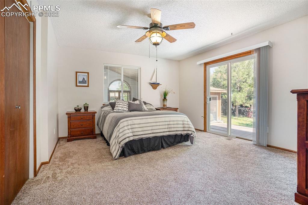 4810 Airport Road Colorado Springs, CO 80916 - Photo 13 of 41 a bedroom with a bed and a chandelier