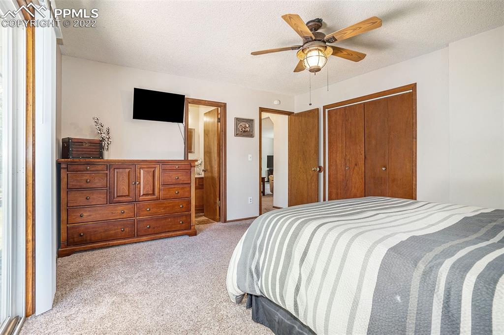 4810 Airport Road Colorado Springs, CO 80916 - Photo 14 of 41 a bedroom with a bed and a chandelier
