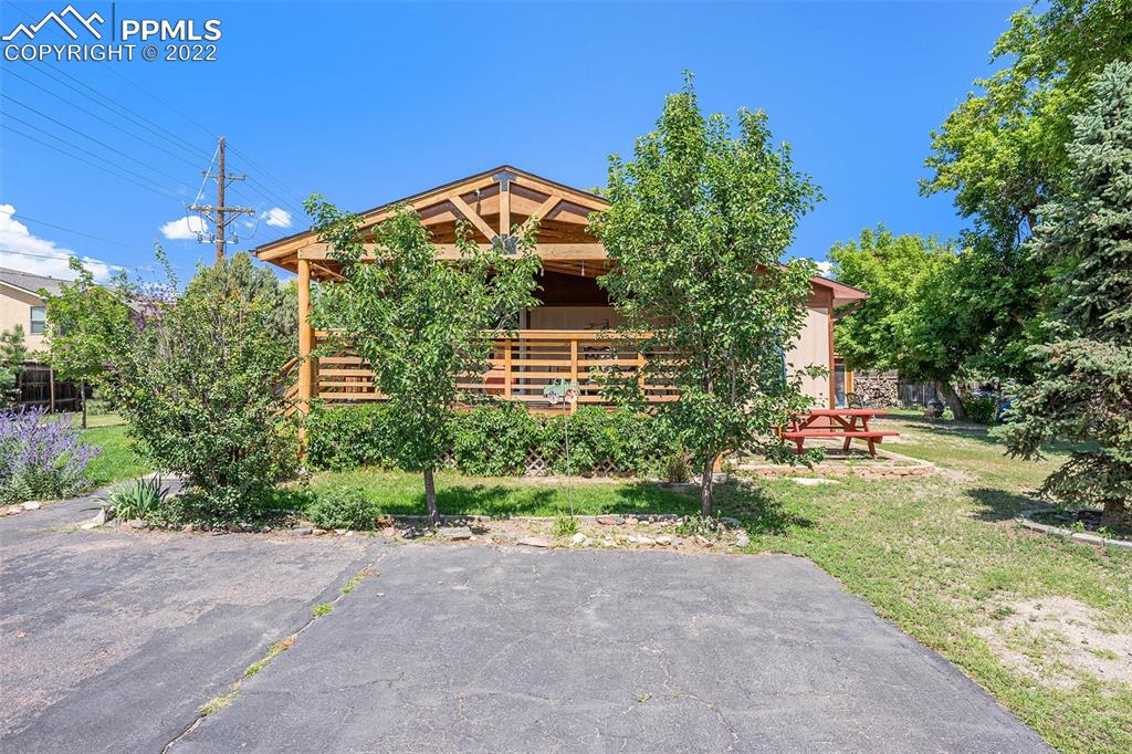 4810 Airport Road Colorado Springs, CO 80916 - Photo 2 of 41 a front view of a house with a yard and garage