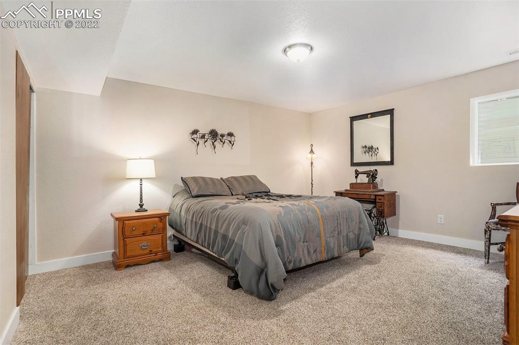 4810 Airport Road Colorado Springs, CO 80916 - Photo 24 of 41 a spacious bedroom with a bed and a lamp