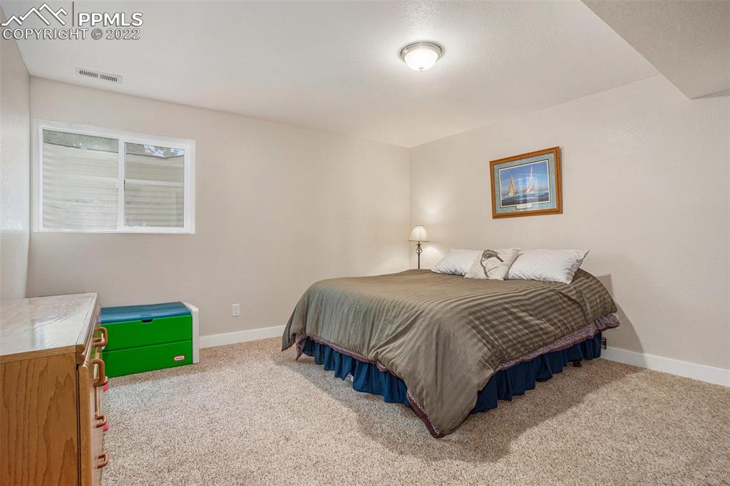 4810 Airport Road Colorado Springs, CO 80916 - Photo 25 of 41 a spacious bedroom with a bed and a couch