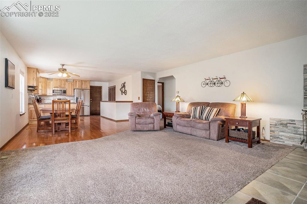 4810 Airport Road Colorado Springs, CO 80916 - Photo 8 of 41 a living room with furniture and a dining table with kitchen view